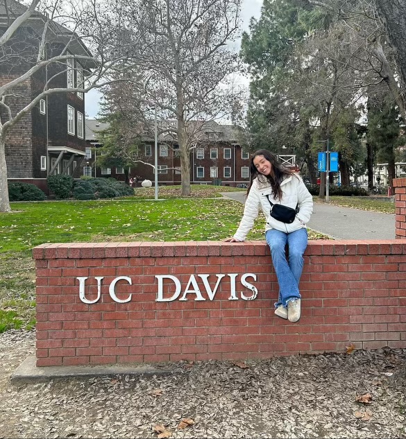 Track and Cross Country star Lauren Villegas smiles proudly next to the sign of UC Davis, the school she has recently decided to commit to.